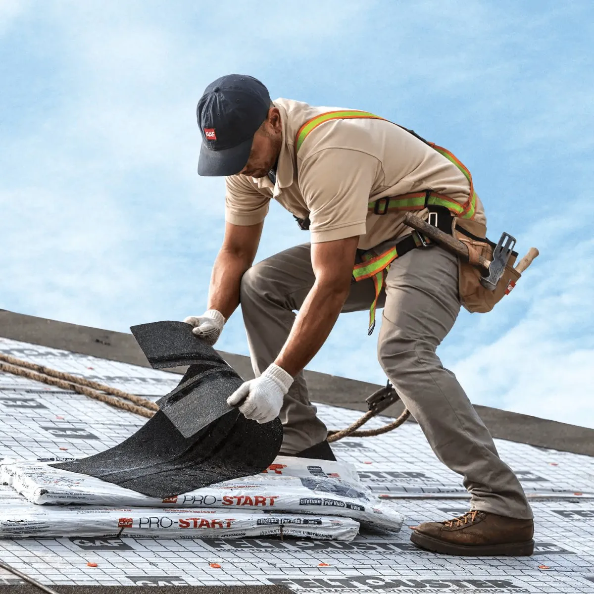Roofer laying starter strip at the eave