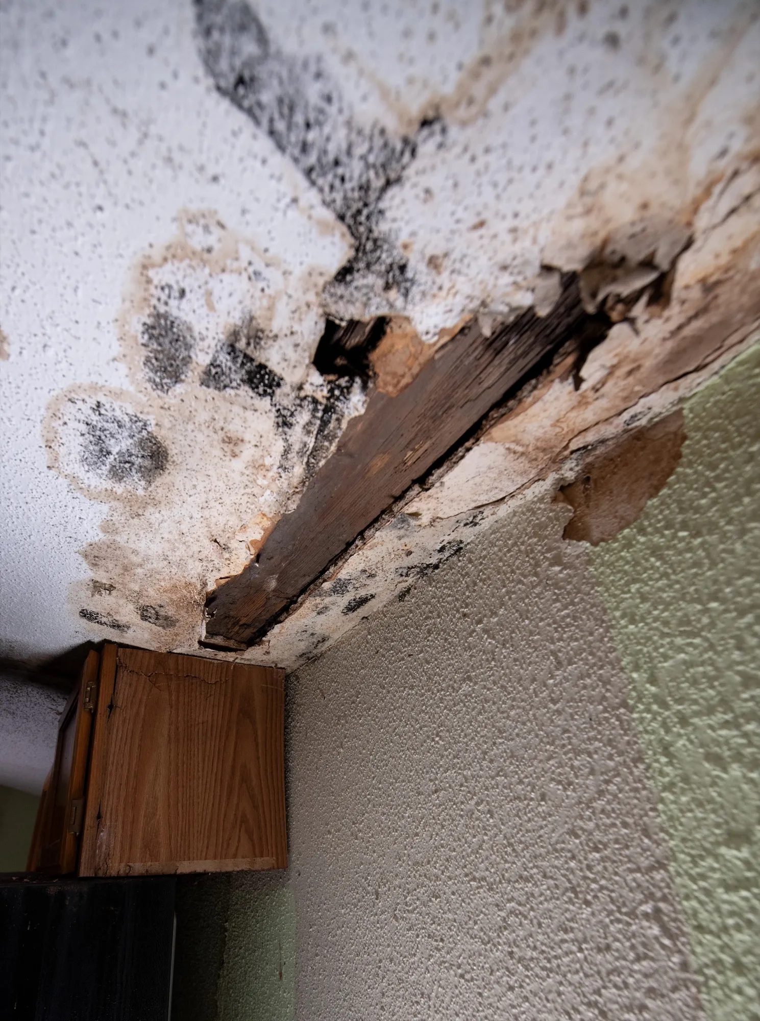 A stained, broken ceiling where storm water came through