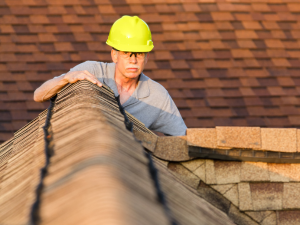 Insured Roswell Roofing professional performing a roof inspection.